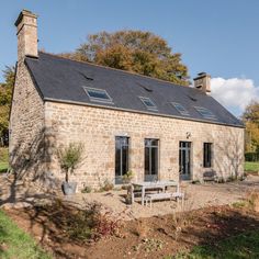 an old brick house with a picnic table in the front yard