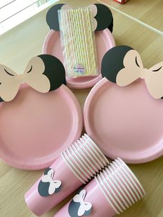 pink mickey mouse plates and napkins on a table