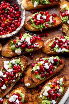 baked bread with guacamole and pomegranates on top, along with other appetizers