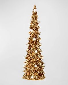 a gold christmas tree ornament hanging on a white wall