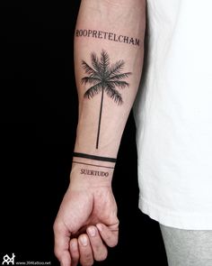 a man with a palm tree tattoo on his arm holding the hand of another person