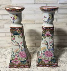 two vases sitting on top of a marble counter