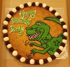 a birthday cake with an image of a dinosaur on it