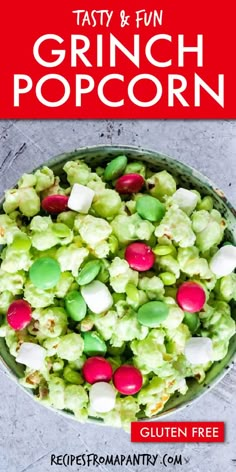 a bowl filled with green and pink candy popcorn on top of a table next to a red sign that says tasty & fun grin popcorn