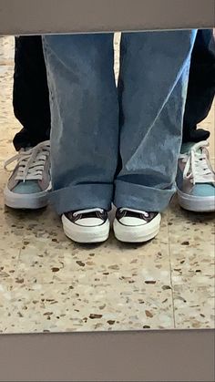 two people standing next to each other with their feet on top of one another's shoes