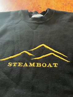 Vintage Steamboat Springs Colorado Crewneck Sweatshirt  Size Large See pics for measurements  Quality Embroidered Graphic  Black Color with Gold Embroidered Logo  Quality Made in USA  Excellent condition.  Appears to have been worn very little if at all  Quick shipping   We ship same or next day with USPS mail  We are a small family business and we appreciate your purchase, Godspeed ! Black Crew Neck Tops With Embroidered Graphics, Retro Crew Neck T-shirt With Team Name, Black Crew Sweatshirt With Embroidered Text, Black Embroidered Text Sweatshirt Crew Neck, Vintage Travel Sweatshirt, Colorado Springs Sweatshirt, Colorado Crewneck, Steamboat Springs Colorado, Steamboat Springs