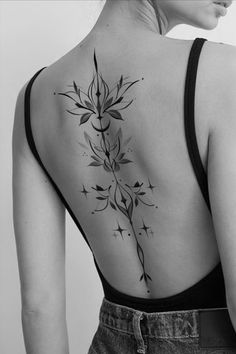 the back of a woman's shoulder with flowers and stars on her left side