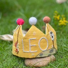 a yellow crown sitting on top of a rock in the grass