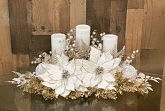 a table topped with candles and flowers on top of a glass table covered in wood planks