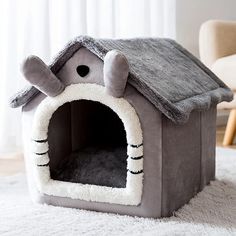 a gray dog house with a cat in it's bed on top of a white rug