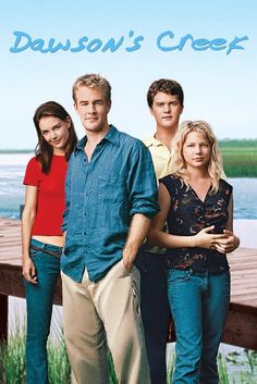 a group of people standing next to each other on a pier near the ocean and water