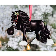 a black horse ornament hanging from a christmas tree