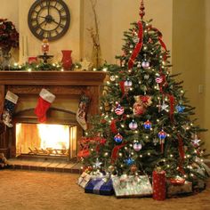 a decorated christmas tree sitting in front of a fire place with stockings on the mantle