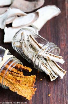 a glass jar filled with food sitting on top of a wooden table next to other items