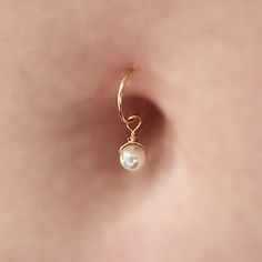 an earring with a single pearl hanging from it's side, on top of a pink background