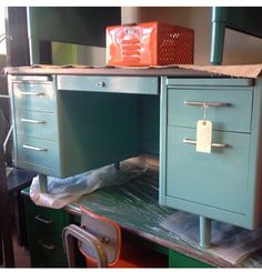 an office desk with two drawers and a chair in front of it on top of a table