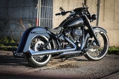 a black motorcycle is parked on the side of the road in front of a building