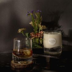 a candle sitting on top of a table next to a vase with flowers in it