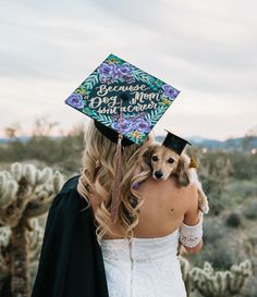 a woman holding a dog wearing a graduation cap