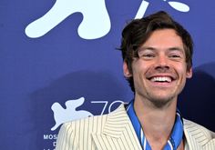 a man in a suit smiling for the camera