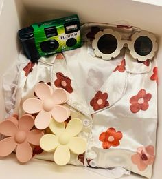 the contents of a diaper are laid out in a box with sunglasses on top