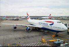 an airplane parked on the tarmac with other planes in the background