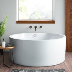 a large white bath tub sitting next to a window