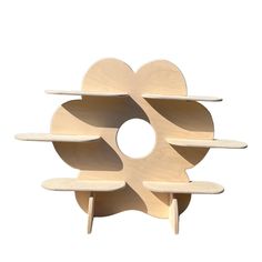 a wooden sculpture with multiple shelves on each side and an oval hole in the middle