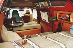 the interior of a camper van with two beds and a laptop on the bed