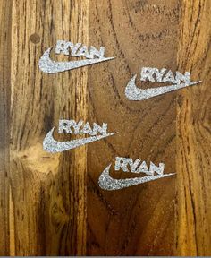 four nike decals are on the side of a wooden wall with woodgrain