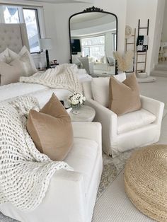 a living room filled with white furniture and pillows