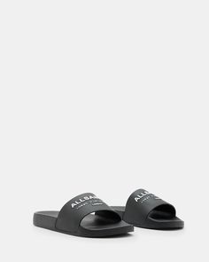 Moulded from rubber, our Underground Slides are essential for chilled out summer styling. Our iconic signature features across the strap. From London to Tokyo - that's the bestselling Underground logo. An ideal casual staple for hot days, or even team them with matching socks - it's a look. If you are between sizes, we recommend sizing up Slides Round toe Moulded silhouette Slip on AllSaints Underground logo Casual Beach Slides, Summer Beach Slides With Logo, Casual Adjustable Slides For Sports, Adjustable Casual Sports Slides, Adjustable Casual Slides For Sports, Modern Slides For Spring Streetwear, Casual Black Slides With Logo, Black Logo Slides For Summer, Athleisure Sports Slides For Summer