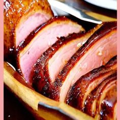 sliced ham sitting in a wooden bowl on top of a table