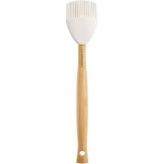 a white brush with wooden handle on a white background