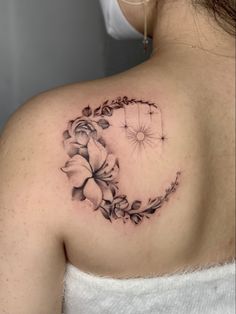 a woman's shoulder with a flower tattoo on it