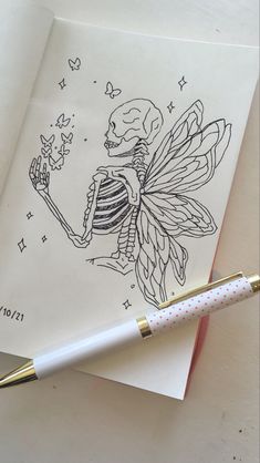 a drawing of a skeleton fairy holding a wand on top of a piece of paper