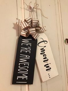 two black and white welcome home signs hanging from a door hanger with ribbons on them