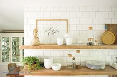 the shelves in the kitchen are filled with dishes and plates, including cups and bowls