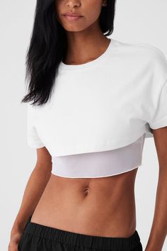 Designed with a boxy, heavyweight cotton top and a tight mesh lining that hits at the ribcage, this is the studio-to-street crop you’ll wear nonstop. This easy silhouette lends a ’90s vibe to any outfit—throw it on over a workout set on the way to yoga or pair it with trousers for a cool city look. White Stretch Alo Yoga Top, Fitted White Alo Yoga Top, Alo Yoga White Stretch Top, Sporty Layering Crop Top, White Crew Neck Crop Top For Layering, Alo Yoga Cotton Athleisure Tops, Alo Yoga Workout Tops For Summer, Alo Yoga Summer Athleisure Top, Alo Yoga Summer Workout Tops