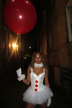 a woman in a white corset holding a red balloon