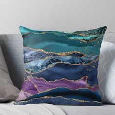 a blue and purple pillow sitting on top of a couch