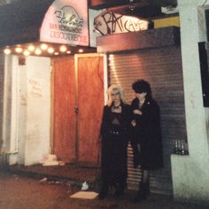 two people standing in front of a building