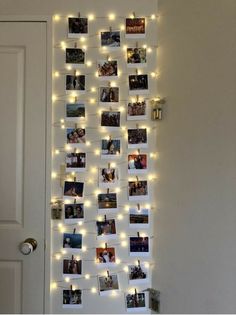 a white door with pictures hanging on it and lights strung from the wall behind them