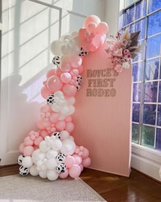 a balloon arch with pink and white balloons