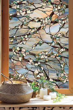 a large stained glass window sitting on top of a wooden table next to a basket