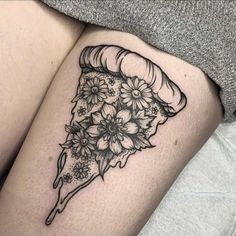 a woman's thigh with a piece of pizza and flowers on it