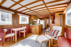 a living room filled with furniture and wooden walls