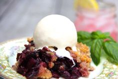 a piece of pie on a plate with ice cream and mint leaves next to it