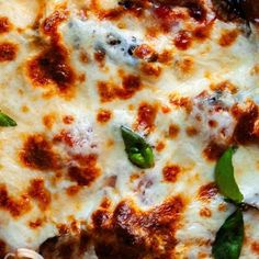 a pizza with cheese and spinach leaves on it's crust is seen from above