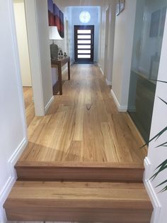 an empty hallway with wooden steps leading to the front door